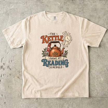 Ivory reading T-shirt with “The Kettle Knows My Reading Schedule” and an illustrated copper kettle