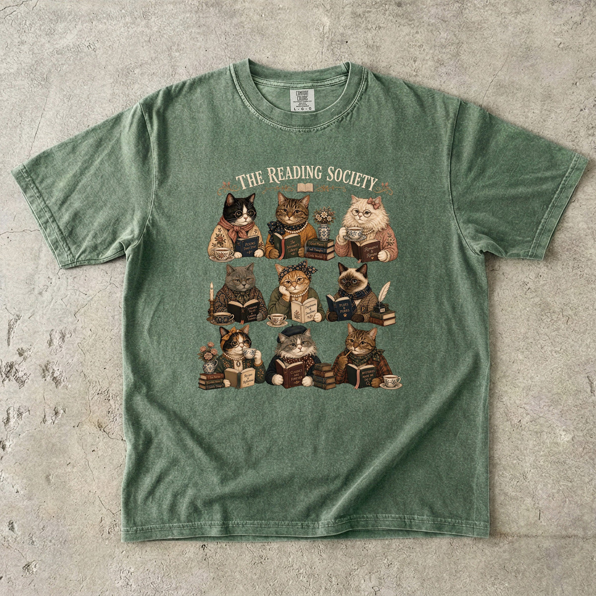 The Reading Society cat book club T-shirt in Moss featuring nine cats reading books with teacups and vintage accessories