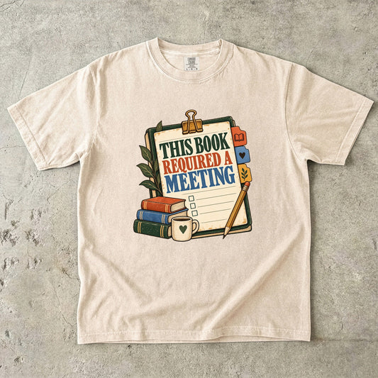 Ivory book club T-shirt with “This Book Required a Meeting” on an illustrated reading agenda