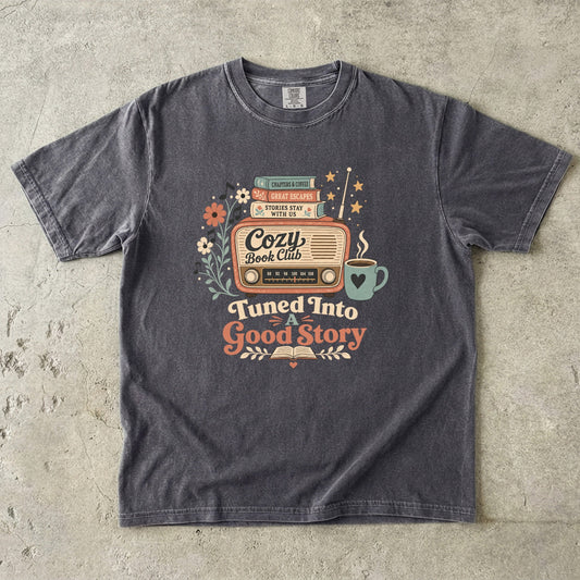 Front view of a Pepper Comfort Colors Book Lover T-shirt featuring the Tuned Into a Good Story vintage retro radio illustration with books and coffee.