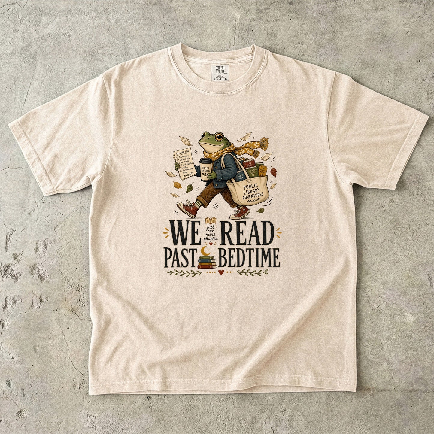 Ivory Comfort Colors We Read Past Bedtime T-shirt with a whimsical frog carrying books and public library finds.